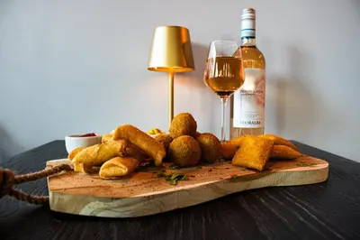 a table with a plate of food and a glass of wine at Grand Hotel Downtown in Amsterdam
