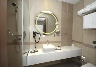 a bathroom with a sink and a shower with a mirror at Grand Hotel Downtown in Amsterdam