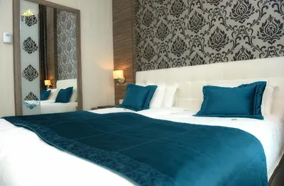 a hotel room with a large bed with blue pillows at Grand Hotel Downtown in Amsterdam