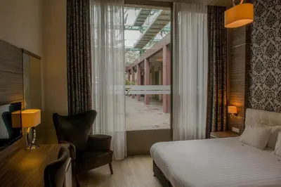 a bedroom with a bed and a window and a chair at Grand Hotel Downtown in Amsterdam