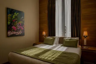 a bedroom with a bed with a painting on the wall at Grand Hotel Downtown in Amsterdam