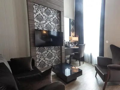 a living room with a fireplace and a tv at Grand Hotel Downtown in Amsterdam
