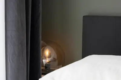 a bedroom with a bed and a candle on a table at Hotel en Stadscafé de Dam l Hotel Monnickendam in Monnickendam