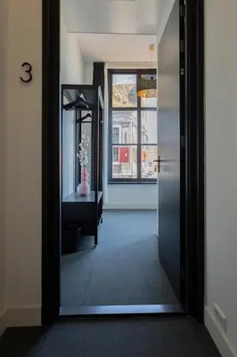 a hallway with a mirror and a desk and a window at Hotel en Stadscafé de Dam l Hotel Monnickendam in Monnickendam