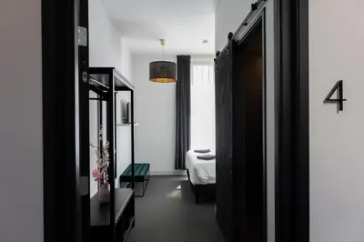 a room with a bedroom with a bed and a mirror at Hotel en Stadscafé de Dam l Hotel Monnickendam in Monnickendam