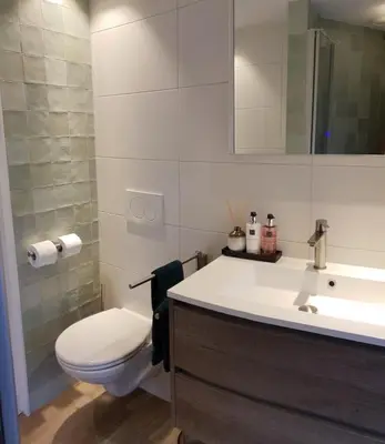 a bathroom with a sink and a toilet and a mirror at Canal view suite in Amsterdam