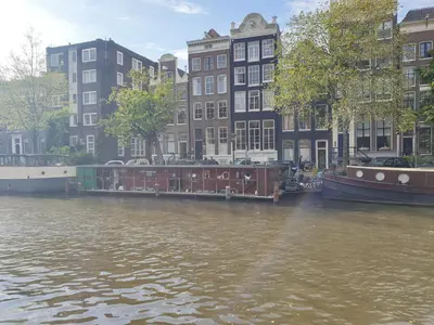 a group of boats on a river with buildings at Canal view suite in Amsterdam