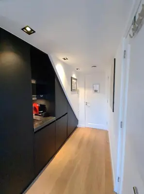a hallway with black cabinets and a kitchen at Canal view suite in Amsterdam