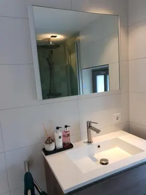 a white bathroom with a sink and a mirror at Canal view suite in Amsterdam