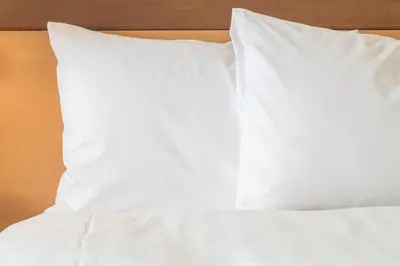 a bed with white sheets and pillows on it at Holiday Inn Express Utrecht - Papendorp by IHG in Utrecht