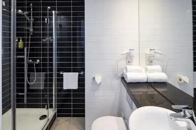a bathroom with a shower and a sink and a toilet at Holiday Inn Express Utrecht - Papendorp by IHG in Utrecht