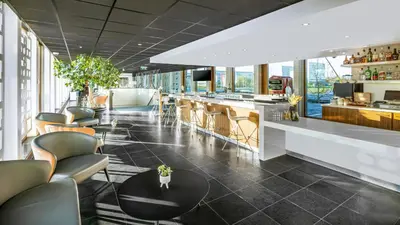 a lobby with chairs and a table in a building at Holiday Inn Express Utrecht - Papendorp by IHG in Utrecht