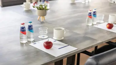 a table with an apple and water bottles on it at Holiday Inn Express Utrecht - Papendorp by IHG in Utrecht