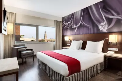 a hotel room with a bed and a window at NH Amersfoort in Amersfoort