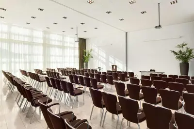 a conference room with rows of chairs and tables at NH Amersfoort in Amersfoort