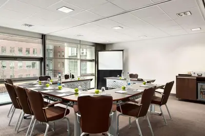 a conference room with a long table and chairs at NH Amersfoort in Amersfoort