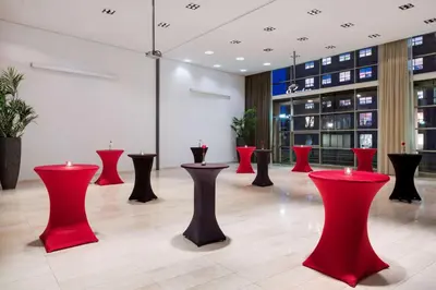 a room with red and black stools in a building at NH Amersfoort in Amersfoort