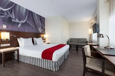 a hotel room with a bed and a desk at NH Amersfoort in Amersfoort