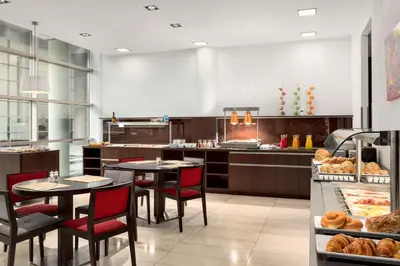 a restaurant with two tables and chairs and a bakery at NH Amersfoort in Amersfoort
