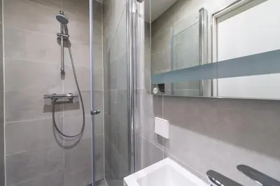 a bathroom with a shower and a sink and a mirror at Prinsengracht Canal Studios in Amsterdam