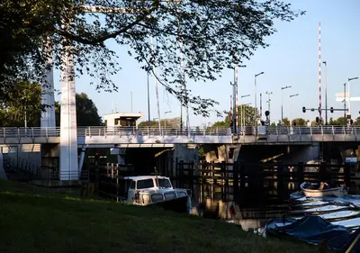 a boat in the water under a bridge at SWEETS - Meeuwenpleinbrug in Amsterdam