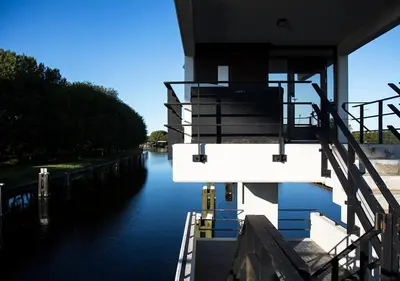 a building with stairs on the side of a canal at SWEETS - Meeuwenpleinbrug in Amsterdam