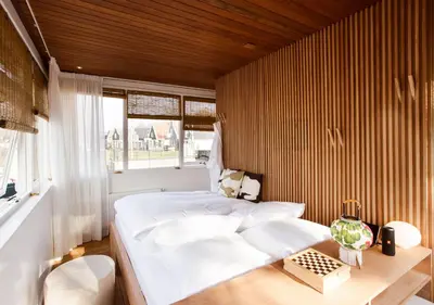 a bedroom with a white bed and a wooden wall at SWEETS - Buiksloterdraaibrug in Amsterdam