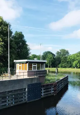 a small house on a dock on a river at SWEETS - Buiksloterdraaibrug in Amsterdam