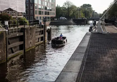 a man in a boat in a canal at SWEETS - Scharrebiersluis in Amsterdam