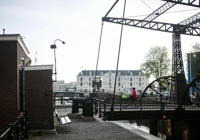 a person walking on a bridge over a body of water at SWEETS - Scharrebiersluis in Amsterdam