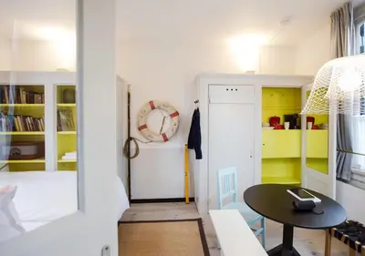 a small room with a table and yellow cabinets at SWEETS - Scharrebiersluis in Amsterdam
