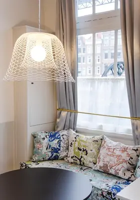 a room with a couch and a table and a lamp at SWEETS - Scharrebiersluis in Amsterdam