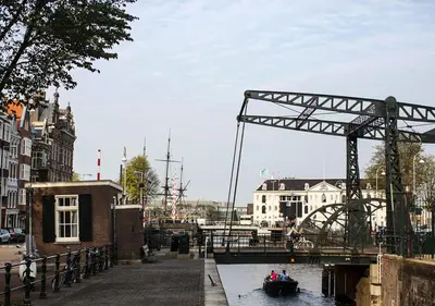 a boat in the water next to a bridge at SWEETS - Scharrebiersluis in Amsterdam