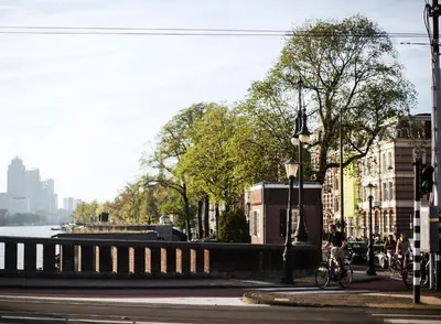 a person riding a bike on a city street at SWEETS - Nieuwe Amstelbrug in Amsterdam