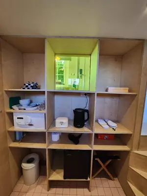 a small kitchen with wooden shelves and a mirror at SWEETS - Nieuwe Amstelbrug in Amsterdam