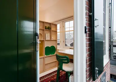 a room with a green door and a green chair at SWEETS - Nieuwe Amstelbrug in Amsterdam