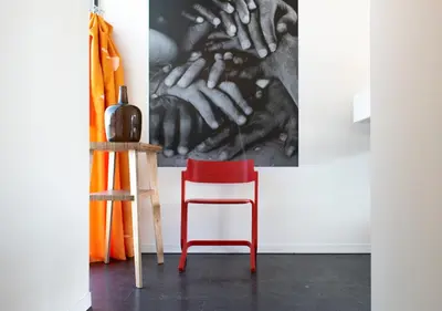 a red chair in a room with a painting on the wall at SWEETS - Sluis Haveneiland in Amsterdam
