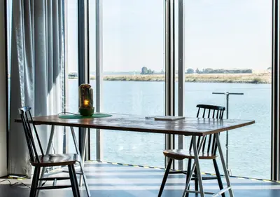 a table with two chairs in front of a large window at SWEETS - Sluis Haveneiland in Amsterdam