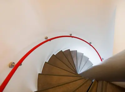 a view of a spiral staircase with a red hose at SWEETS - Westerdoksbrug in Amsterdam