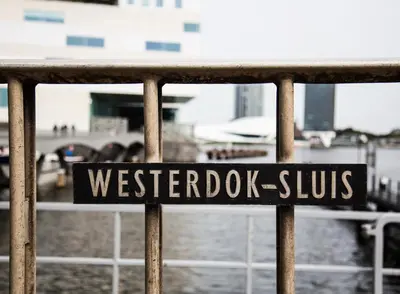 a sign that reads westbridge cuts on a fence at SWEETS - Westerdoksbrug in Amsterdam