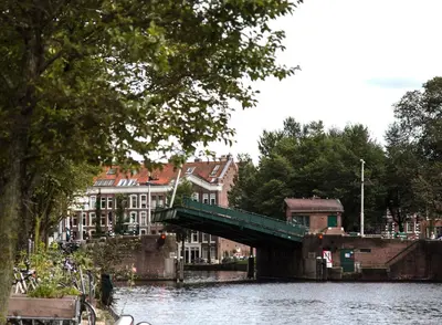 a bridge over a river with houses and buildings at SWEETS - Kattenslootbrug in Amsterdam
