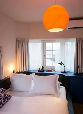 a bedroom with a bed with white pillows and a window at SWEETS - Beltbrug in Amsterdam