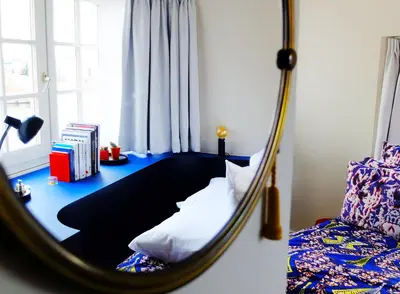 a mirror in a room with a bed and a couch at SWEETS - Beltbrug in Amsterdam