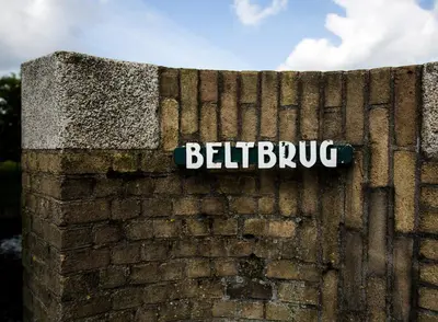 a brick wall with a street sign on it at SWEETS - Beltbrug in Amsterdam