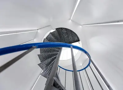 a metal spiral staircase in a white room at SWEETS - Wiegbrug in Amsterdam