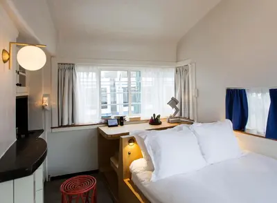 a bedroom with a bed and a desk and a window at SWEETS - Kinkerbrug in Amsterdam