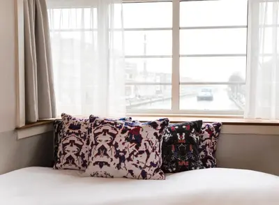 a bed with two pillows in front of a window at SWEETS - Kinkerbrug in Amsterdam