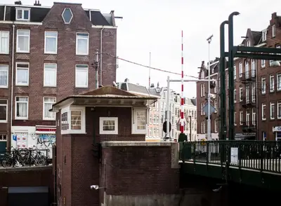 a brick building on a city street with buildings at SWEETS - Kinkerbrug in Amsterdam