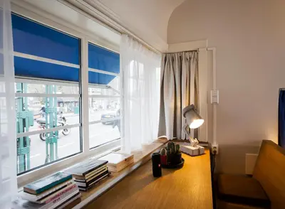a living room with a large window and a table with books at SWEETS - Kinkerbrug in Amsterdam