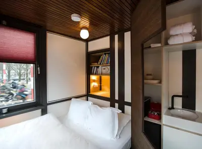 a small bedroom with a bed and a sink at SWEETS - Theophile de Bockbrug in Amsterdam